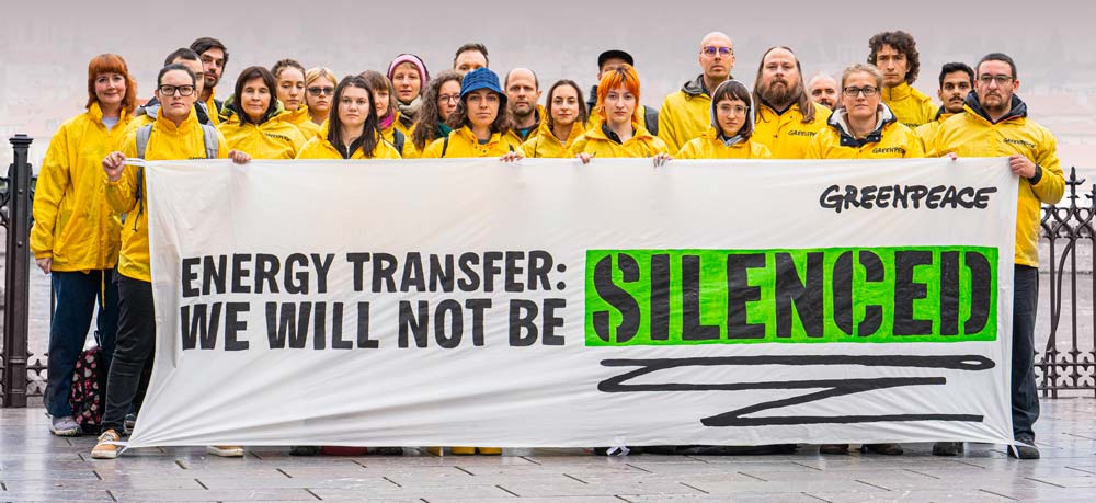 Attivisti di Greenpeace tengono un banner con la scritta Energy Transfer: We will not be silenced